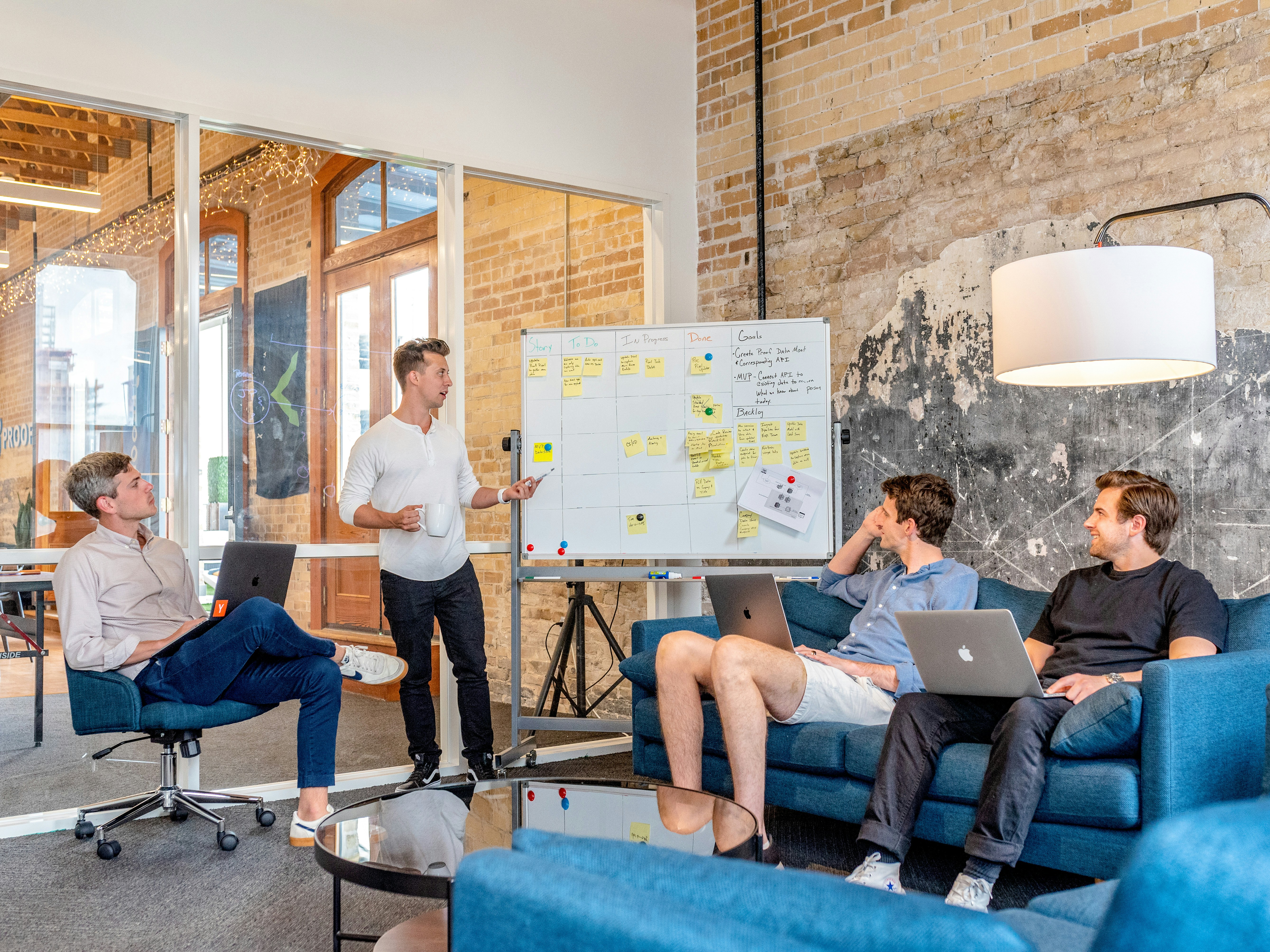 Team collaborating at whiteboard with sticky notes in industrial office
